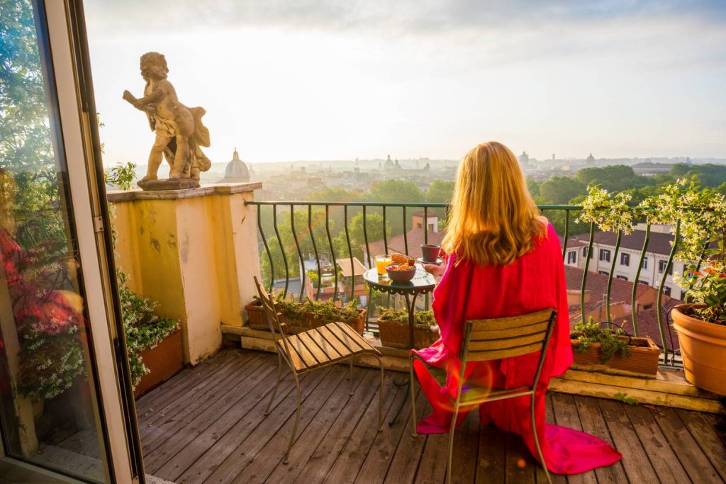 Woman sitting on balcony at sunrise